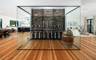 A large wine display area in a glass box room within an open plan space