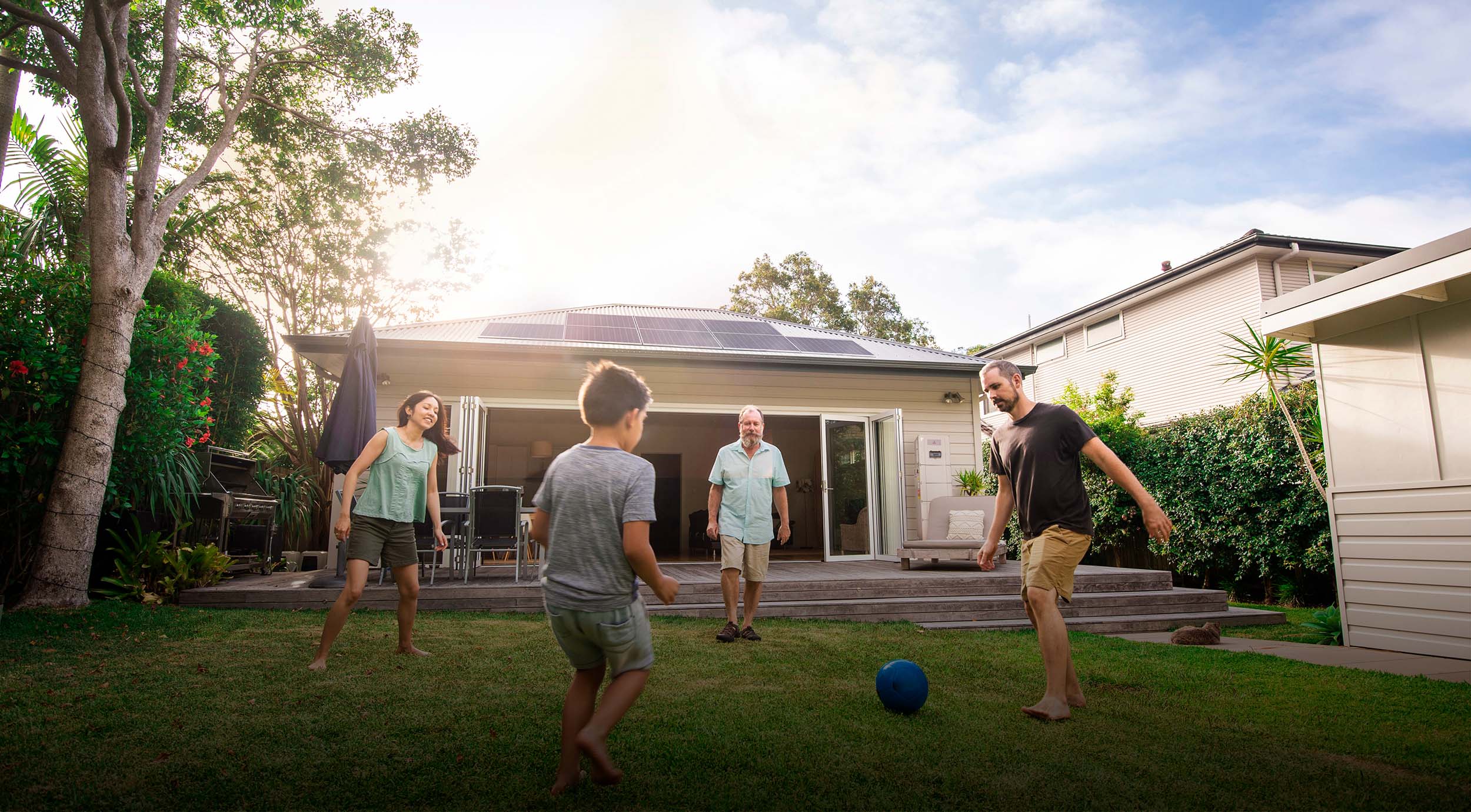 Banner Image Showing Family Playing Soccer infront of House with Solar Panels and Redback Solar Battery