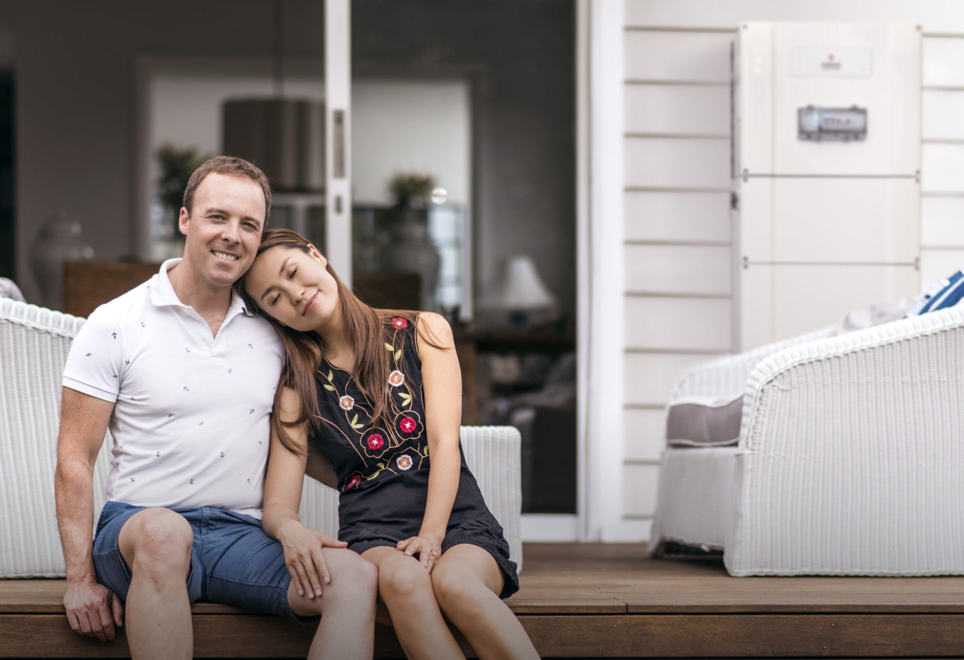 Married Couple embracing with Redback Technologies Smart Battery Installed on their porch