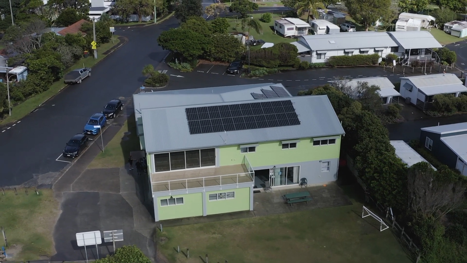 Aerial view of a community building with solar panels on it.
