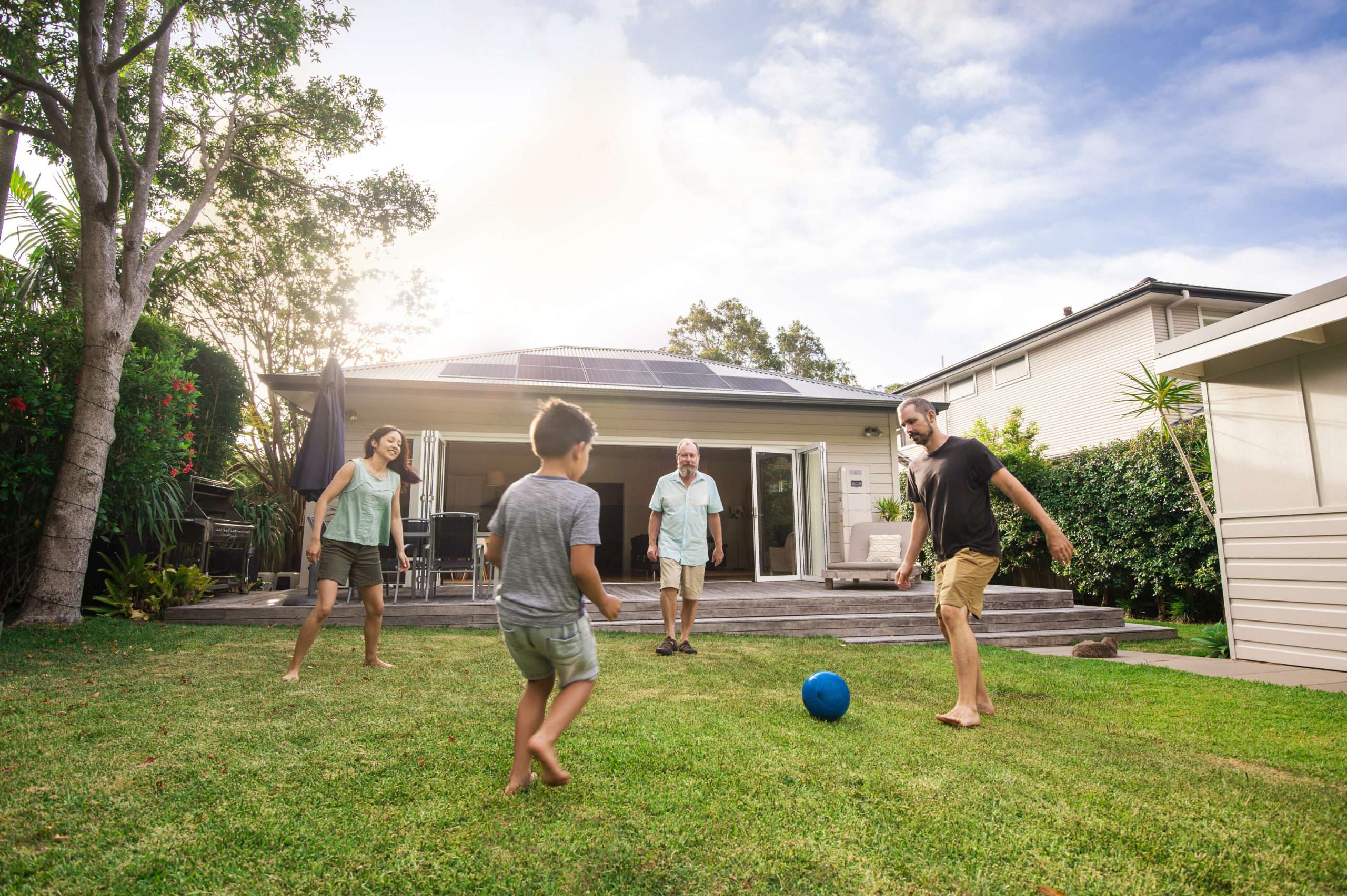 Typical Australian bungalow, family enjoying evening soccer game.